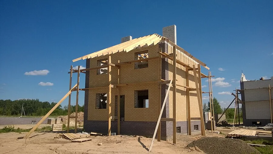 A timber-framed house going up on a construction site